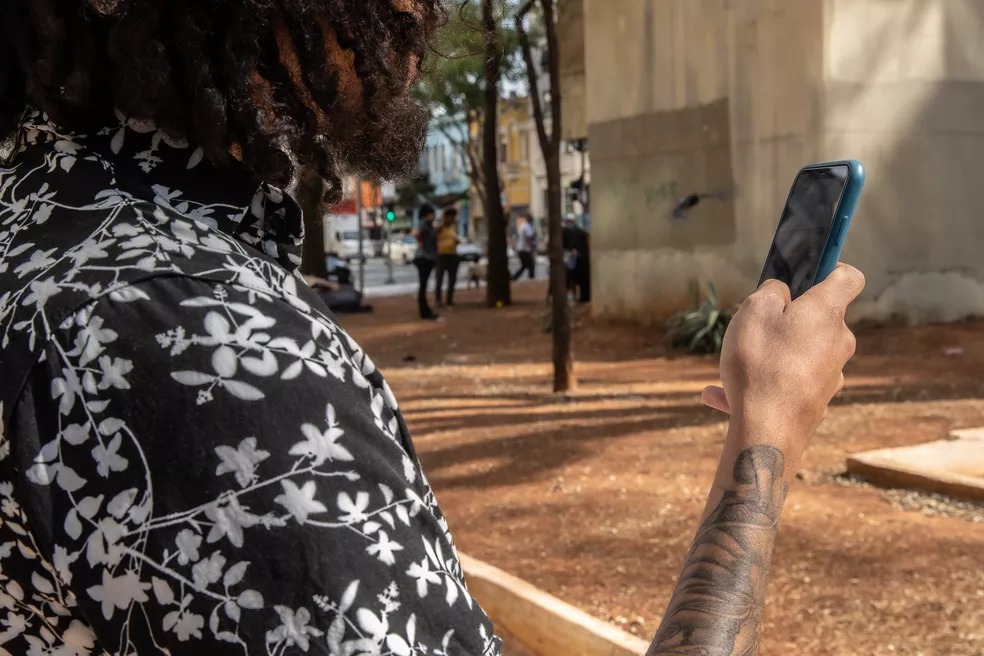 Homem com celular na mão testando o sinal 5G - Foto: Celso Tavares/g1